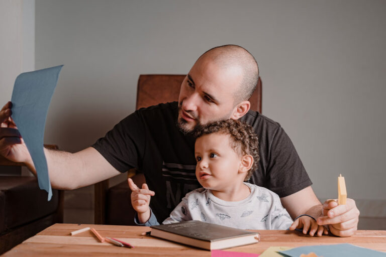 dad-and-son-reviewing-a-sheet-with-painted-picture-2024-11-29-05-22-54-utc