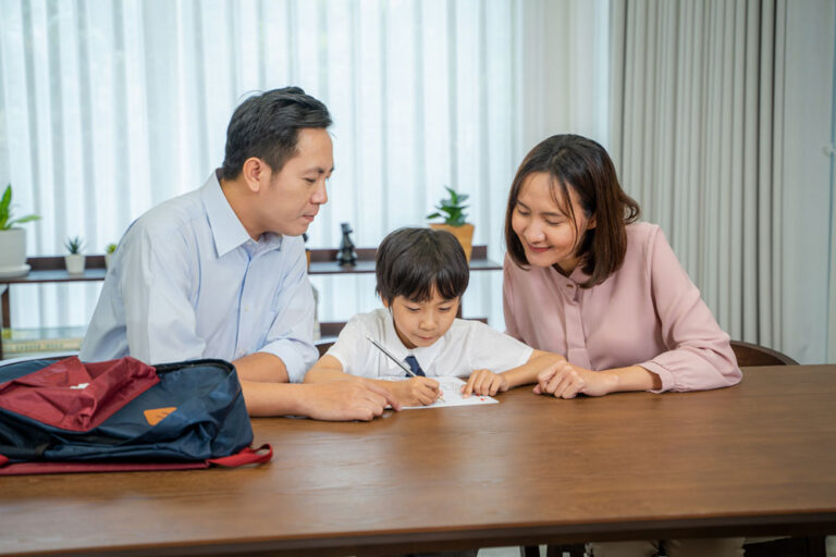 young-boy-doing-his-school-homework-with-parents-b-2023-11-27-05-18-47-utc